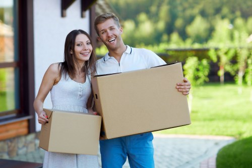 Professional movers carrying furniture through a Roehampton property