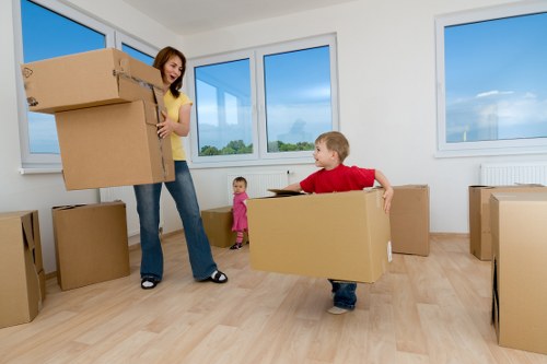 Removal team carrying boxes through a flat entrance in Roehampton