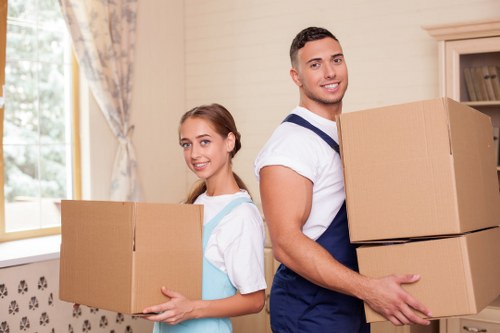 Local movers in Roehampton transporting furniture through a residential street